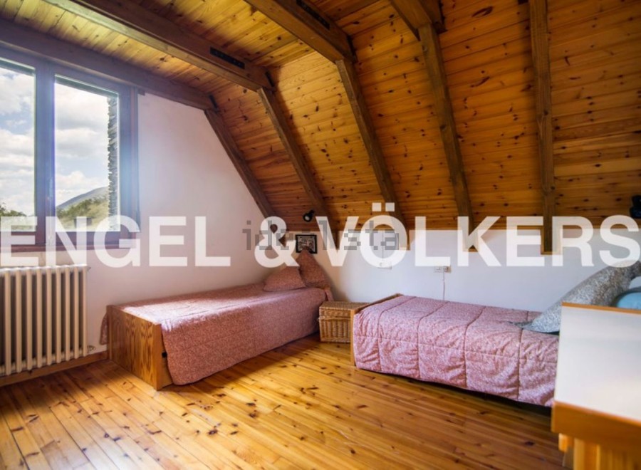 Charming attic bedroom with wooden beams and sloping ceilings.