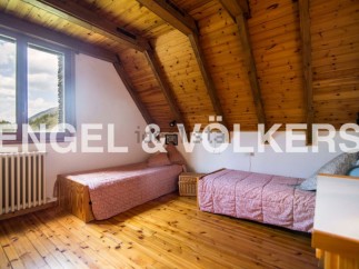 Charming attic bedroom with wooden beams and sloping ceilings.