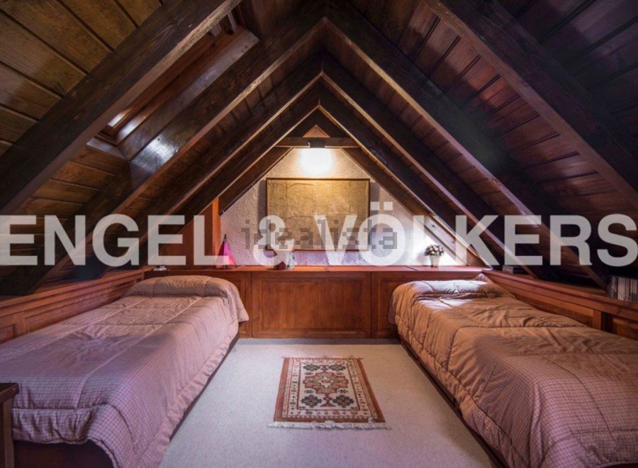 Charming attic bedroom with twin beds, wooden beams, and a cozy atmosphere.