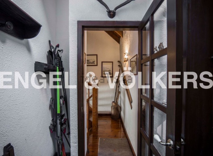 Charming chalet hallway with wooden floors and exposed beams.