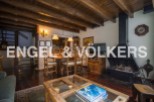 Charming chalet-style living room with exposed wooden beams, a cozy fireplace, and a spacious dining area.