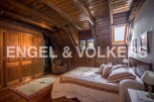 Charming rustic bedroom with wooden beams, skylights, and built-in wardrobe.