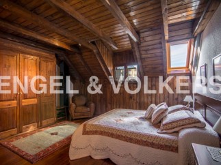 Charming rustic bedroom with wooden beams, skylights, and built-in wardrobe.