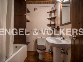 Charming rustic bathroom with wooden features and a bathtub.