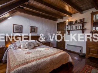 Charming attic bedroom with wooden beams and sloped ceilings.