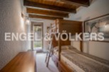 Charming bunk beds in a rustic-style bedroom with wooden beams and a tranquil garden view.