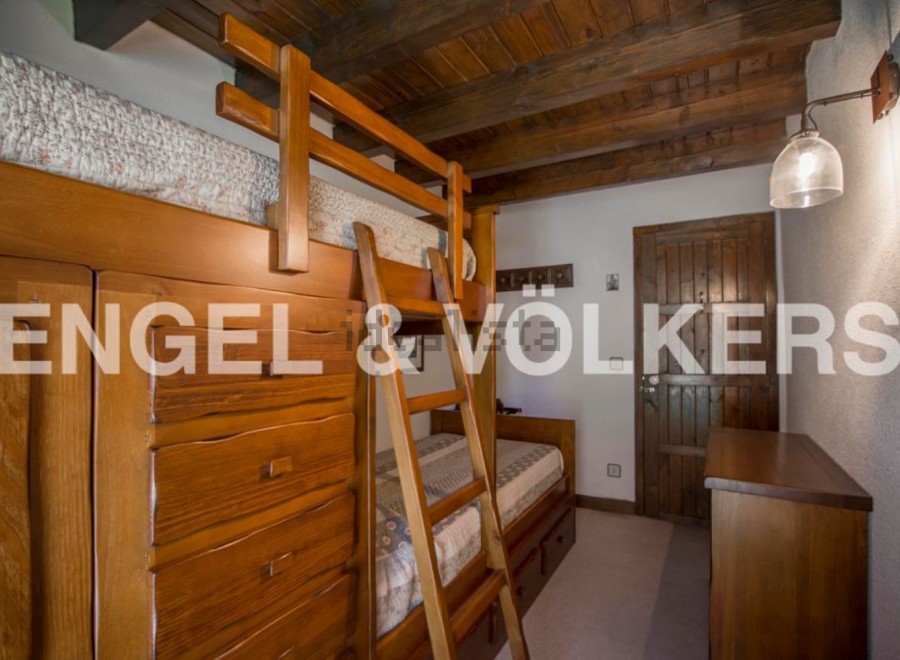 Charming wooden bunk beds with built-in storage create a cozy and functional space in this rustic-style bedroom.