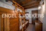 Charming wooden bunk beds with built-in storage create a cozy and functional space in this rustic-style bedroom.