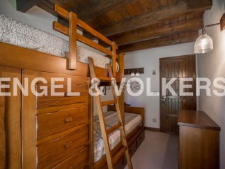Charming wooden bunk beds with built-in storage create a cozy and functional space in this rustic-style bedroom.