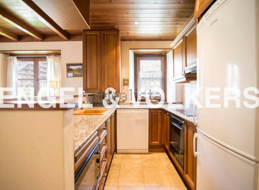 This charming kitchen boasts a rustic wooden ceiling and granite countertops, creating a warm and inviting atmosphere.