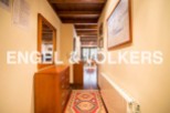 This charming hallway boasts a wooden dresser, a mirror reflecting the cozy interior, and a vibrant rug adding warmth to the wooden floor.