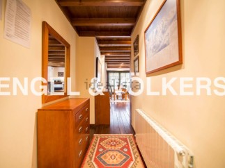 This charming hallway boasts a wooden dresser, a mirror reflecting the cozy interior, and a vibrant rug adding warmth to the wooden floor.