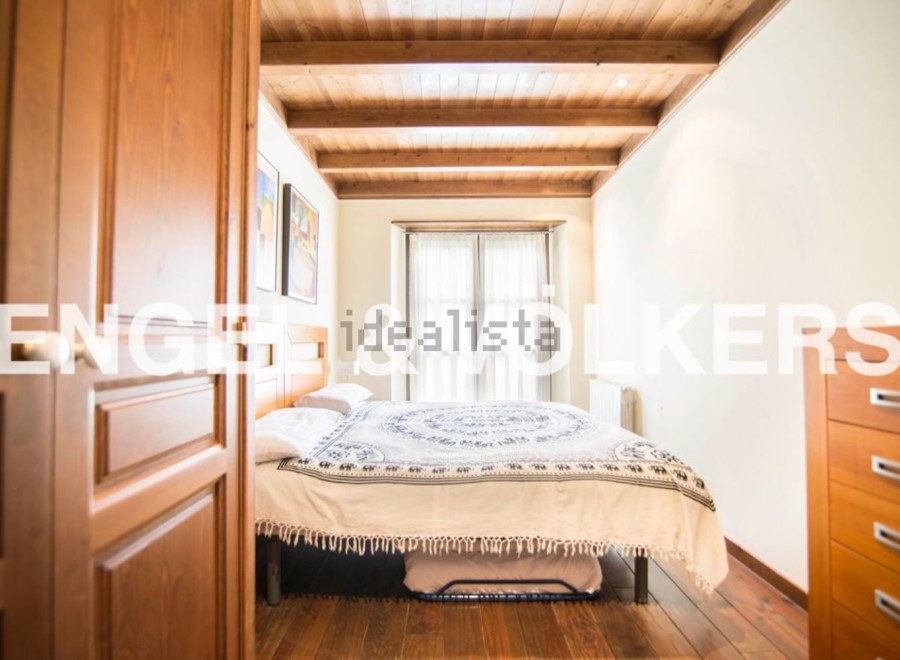 Charming bedroom with wooden beams and hardwood floors.