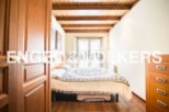 Charming bedroom with wooden beams and hardwood floors.