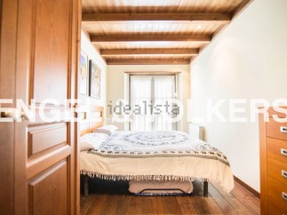 Charming bedroom with wooden beams and hardwood floors.