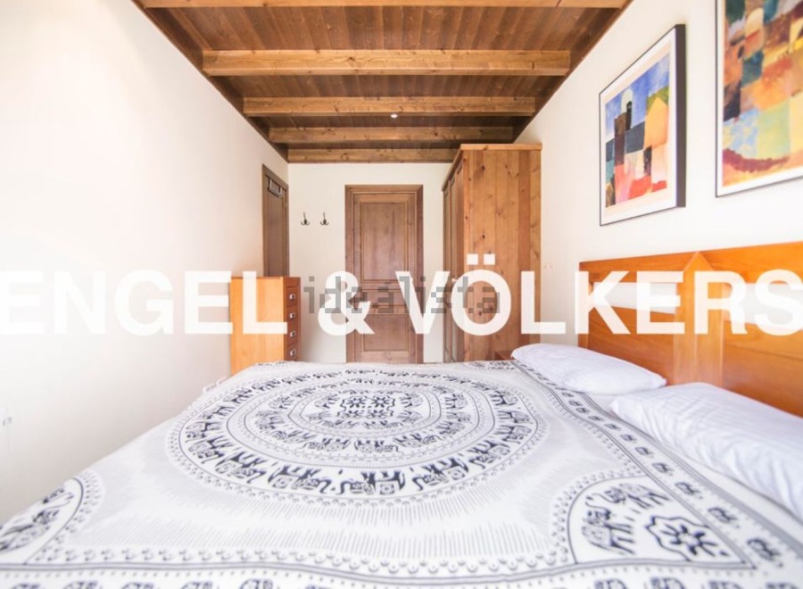 Charming bedroom with wooden ceiling and built-in wardrobe.