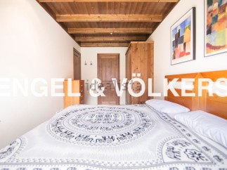 Charming bedroom with wooden ceiling and built-in wardrobe.