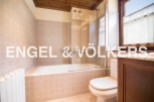 This charming bathroom boasts a classic design with beige tile, a built-in bathtub, and a separate toilet.