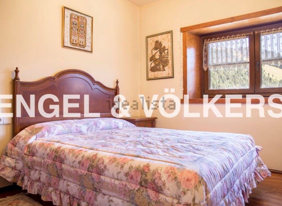 Charming bedroom with floral bedding and wooden headboard.
