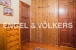 Charming bedroom with built-in wooden wardrobes and chest of drawers.