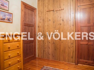 Charming bedroom with built-in wooden wardrobes and chest of drawers.