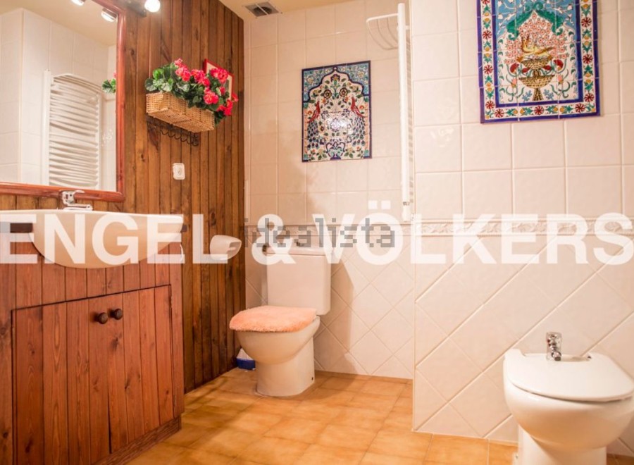 Charming bathroom with wooden vanity and tiled walls.