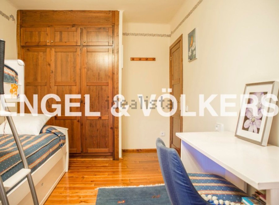 Charming bedroom with built-in wooden wardrobe and bunk bed, perfect for children or guests.