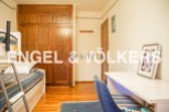 Charming bedroom with built-in wooden wardrobe and bunk bed, perfect for children or guests.