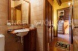 Rustic bathroom with wooden vanity and tiled walls.