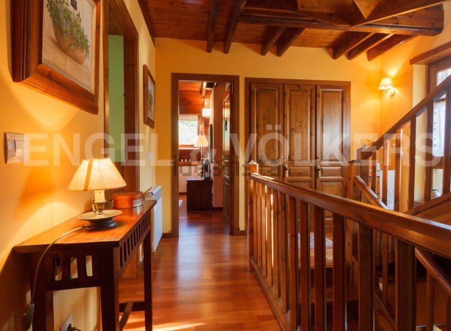 This stunning property boasts a spacious hallway with rich wooden flooring and exposed beams, creating a warm and inviting atmosphere.