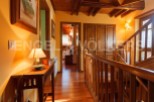 This stunning property boasts a spacious hallway with rich wooden flooring and exposed beams, creating a warm and inviting atmosphere.