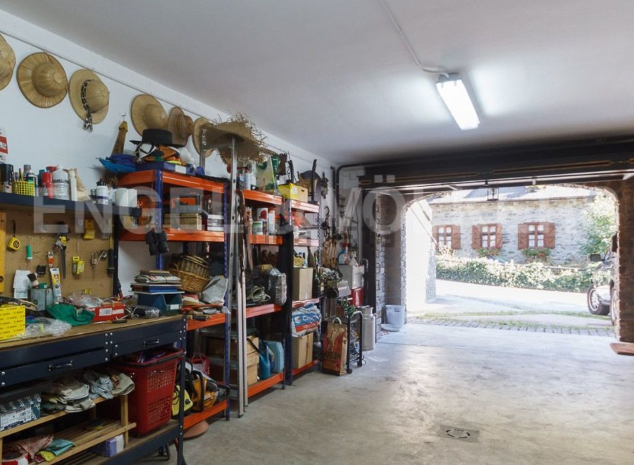 This spacious garage offers ample storage solutions with built-in shelving units, providing plenty of room for tools and equipment.