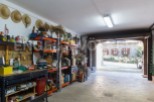This spacious garage offers ample storage solutions with built-in shelving units, providing plenty of room for tools and equipment.