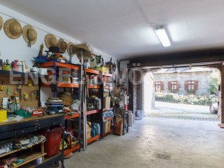 This spacious garage offers ample storage solutions with built-in shelving units, providing plenty of room for tools and equipment.
