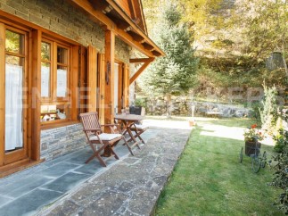 This charming stone and wood cabin boasts a spacious patio perfect for outdoor relaxation.