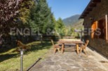 This charming mountain cabin boasts a rustic wooden patio set, perfect for outdoor dining and relaxation.