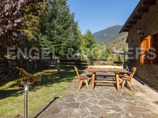 This charming mountain cabin boasts a rustic wooden patio set, perfect for outdoor dining and relaxation.
