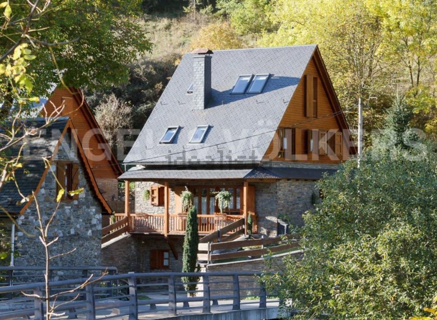 Charming stone house with wooden accents and a slate roof.