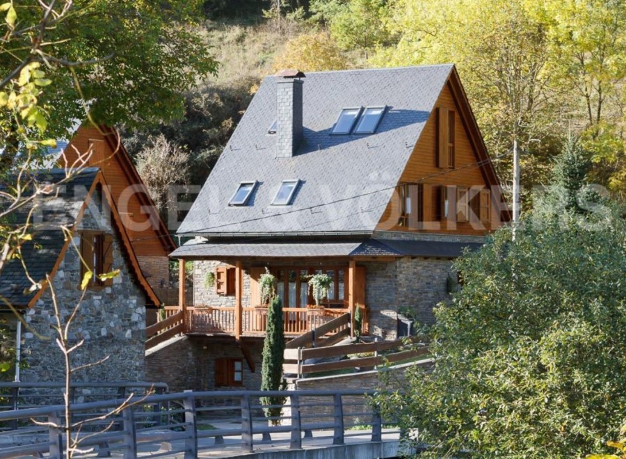 Charming stone house with wooden accents and a slate roof.