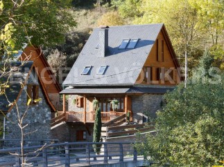 Charming stone house with wooden accents and a slate roof.