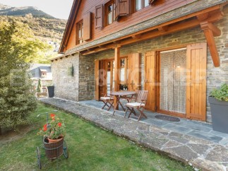 Charming stone house with wooden accents and a cozy patio, perfect for enjoying the mountain views.
