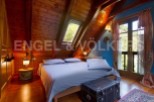 Cozy attic bedroom with wooden beams, skylight, and stunning views.