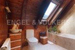 Charming attic bathroom with wooden beams, skylight, and a bathtub.