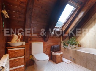 Charming attic bathroom with wooden beams, skylight, and a bathtub.