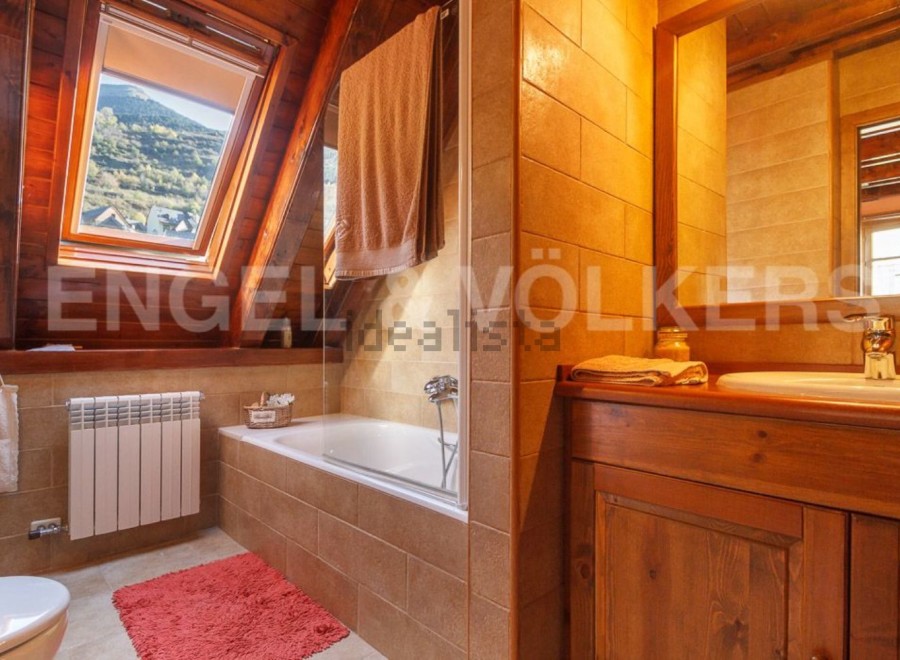 Charming bathroom with wooden finishes and a skylight offering stunning mountain views.