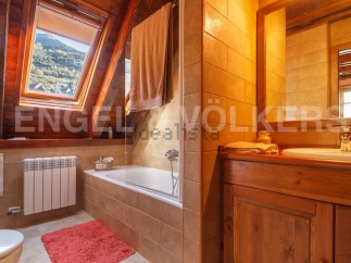 Charming bathroom with wooden finishes and a skylight offering stunning mountain views.