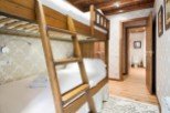 Cozy bunk beds in a charming room with wooden accents and elegant wallpaper.