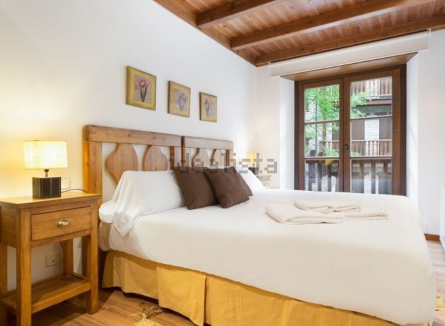 Cozy bedroom with wooden accents and a comfortable double bed.