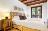 Cozy bedroom with wooden accents and a comfortable double bed.