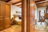 Charming wooden apartment with a cozy bedroom and a bunk bed in a second room.